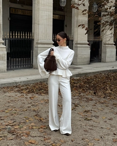 Détail de l'ensemble en tricot blanc avec haut à ourlet volanté et pantalon large d'automne