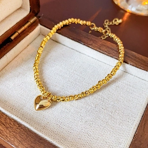 Golden heart charm beaded bracelet displayed in a premium wooden jewelry gift box