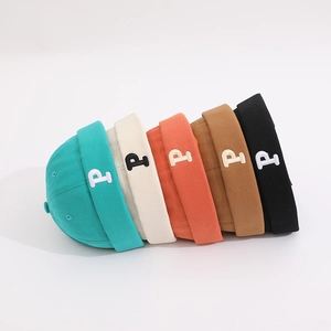 Detail showing various colors of children's brimless hats with P letter embroidery
