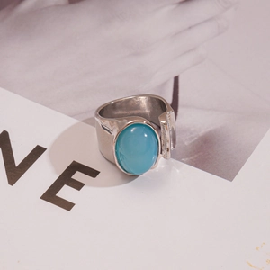 Détail d'une large bague argentée ajustable avec une grande pierre ovale bleu clair