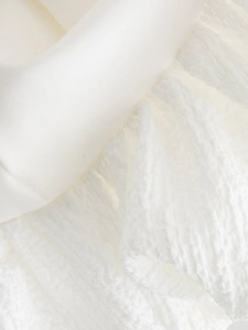 Detailed macro view of white textured bubble fabric and smooth cotton dress material