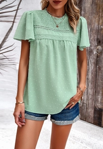 Detail of mint green chiffon top with lace patchwork, polka dots and small stand collar