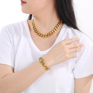 Close-up of 13mm gold Cuban link chain necklace and bracelet with dragon clasp detail