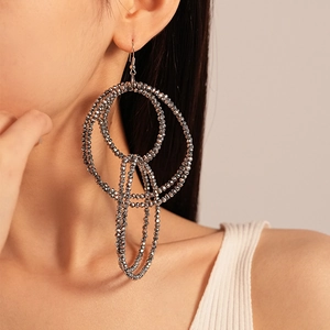 Detailed close-up of layered silver beaded circle earrings on a fashion model