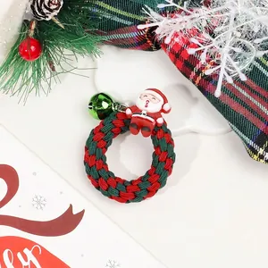 Close-up of a Christmas hair scrunchie with Santa Claus doll and green metal bell detail