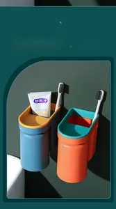 Detail of wall-mounted toothbrush holder with blue and orange plastic storage cups