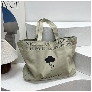 Close-up of canvas tote bag with floral print and NKK Art Studio typography