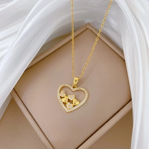 Elegant hollow heart necklace in gold finish with sparkling crystals on silk background