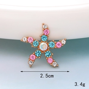 Macro detail of a 2.5cm colorful rhinestone starfish accessory in gold finish
