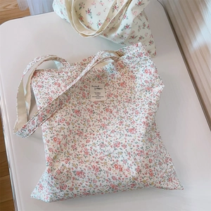 Detailed close-up of a floral cotton canvas tote bag with a vintage aesthetic labels