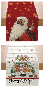 Detail of linen Christmas table runners with Santa and gingerbread house patterns