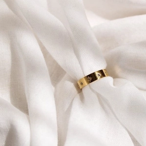 18k gold plated stainless steel North Star signet ring with CZ stones on white fabric