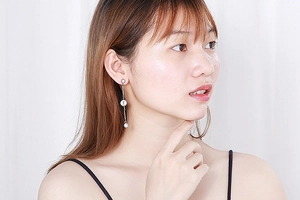 Detail showing elegant long silver tassel earrings with sparkling rhinestones on a model