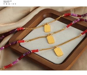 Detailed close-up of golden necklace with colorful beads and Fa Cai relief pendant