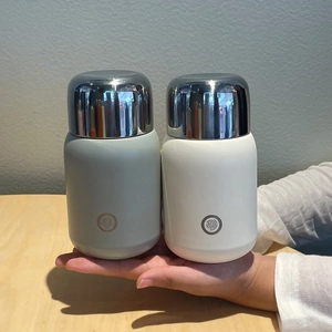 Detail of grey and ivory 316 stainless steel insulated bottles with metallic lids