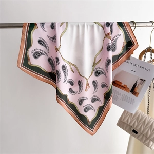 Detail of pink paisley silk scarf hanging on a metal rod showing light and soft texture