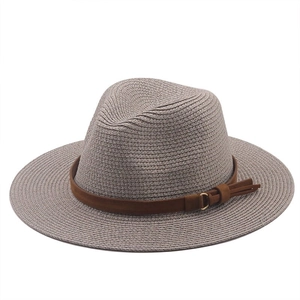 Détail d'un chapeau fedora en paille de raphia avec bande en daim et boucle dorée