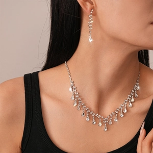 Elegant silver necklace and drop earrings jewelry set with sparkling rhinestones on model