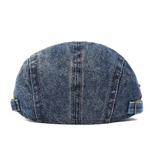 Detail of blue denim beret with adjustable metal buckle and contrast stitching