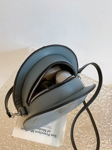 Sac bandoulière rond en cuir PU bleu brume montrant l'intérieur avec rouge à lèvres