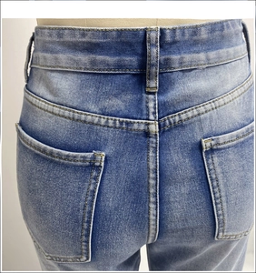 Detail view of high-waisted light blue washed jeans with dual rear pockets and yellow stitching