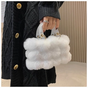 Detailed close-up of a white plush handbag with leather handles and gold metal accents