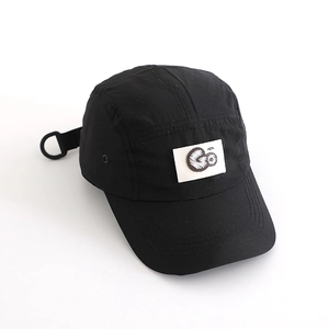Detail of black quick-dry five-panel cap with embroidered GO patch and adjustable strap