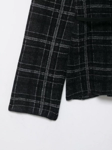 Detail of dark grey plaid knit fabric and matching black belt waist closure