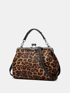 Close-up of leopard print handbag featuring vintage metal clasp and leather handle