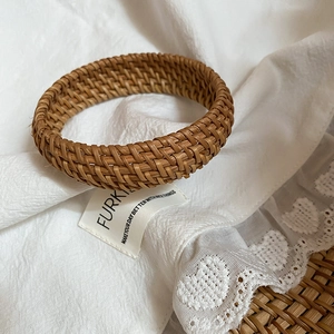 Détail du bracelet en rotin tressé à la main sur dentelle pour style bohème
