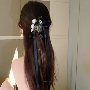 Detail showing elegant black satin bow and pearl tassels on a princess style hair clip