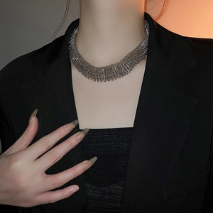 Close-up of a chunky silver mesh collar necklace on a model with metallic weave texture