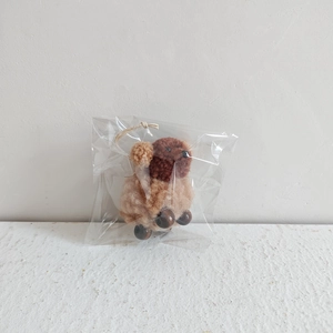 Detail of wool felt lamb ornament with wooden bead legs in clear packaging