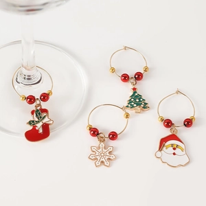 Detail of Christmas wine glass charms with festive motifs attached to a glass base
