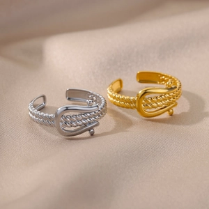 Detailed macro view of adjustable horseshoe gold and silver rings on silk background