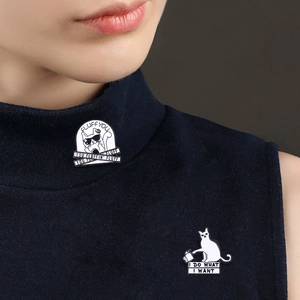 Detail of funny enamel cat pins featuring 'Fluff You' and 'I Do What I Want' text on denim
