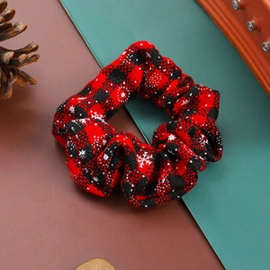 Christmas hair scrunchie with red and black plaid patterns and white snowflake prints