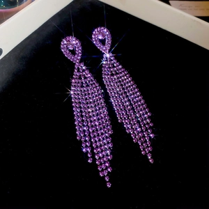 Macro shot of long purple crystal tassel earrings displayed on black velvet jewelry box