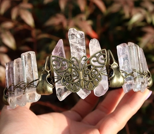 Detail of vintage bronze viking crown with natural pink crystals held by hands