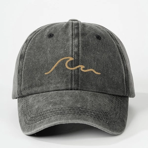 Dettaglio del ricamo a onde gialle su un cappellino in denim lavato grigio scuro