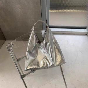 Détail d'un grand sac fourre-tout argenté métallisé sur une chaise moderne