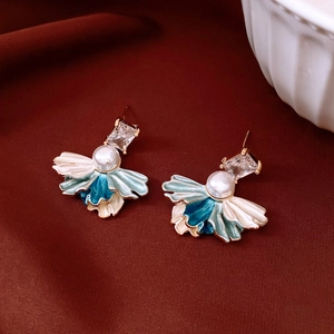 Détail de boucles d'oreilles vintage avec émail bleu, perles et zircon brillant