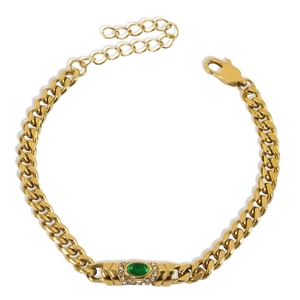 Macro view of gold Cuban link bracelet featuring a green cat-eye stone and rhinestones