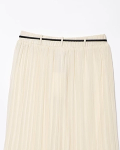 Détail d'une jupe midi plissée crème avec des plis fins et une fine ceinture noire minimaliste