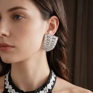 Boucles d'oreilles éventail luxueuses en ton argent avec cristaux portées sur mannequin
