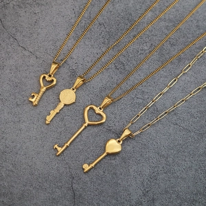 Four vintage heart key pendants in gold stainless steel on assorted necklace chains