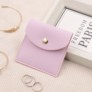 Detail of light purple jewelry pouch with gold snap button and premium leather texture