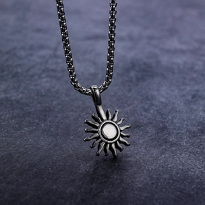 Retro stainless steel sun pendant necklace with 18k gold plating on a stone background