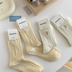 Chaussettes japonaises pastel avec maille torsadée et broderie lettre S en blanc crème