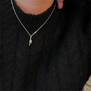 Elegant 925 sterling silver knot pendant necklace worn on a black knit sweater